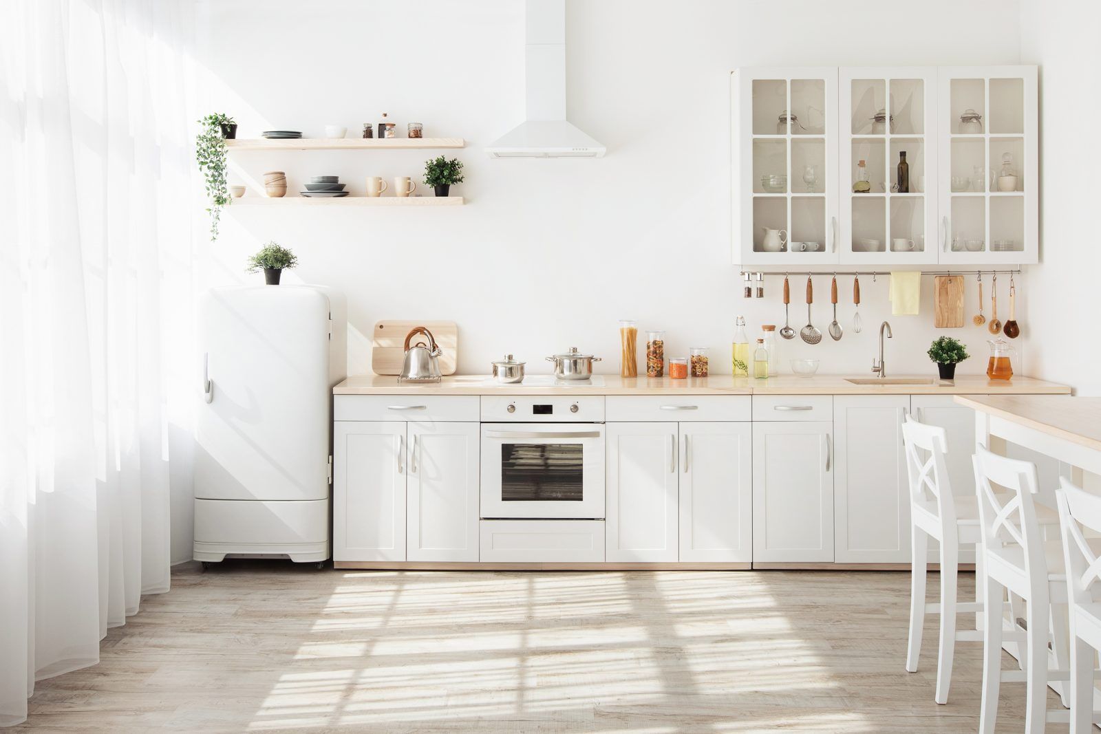 Cocina luminosa con nevera, horno, armarios y fregadero